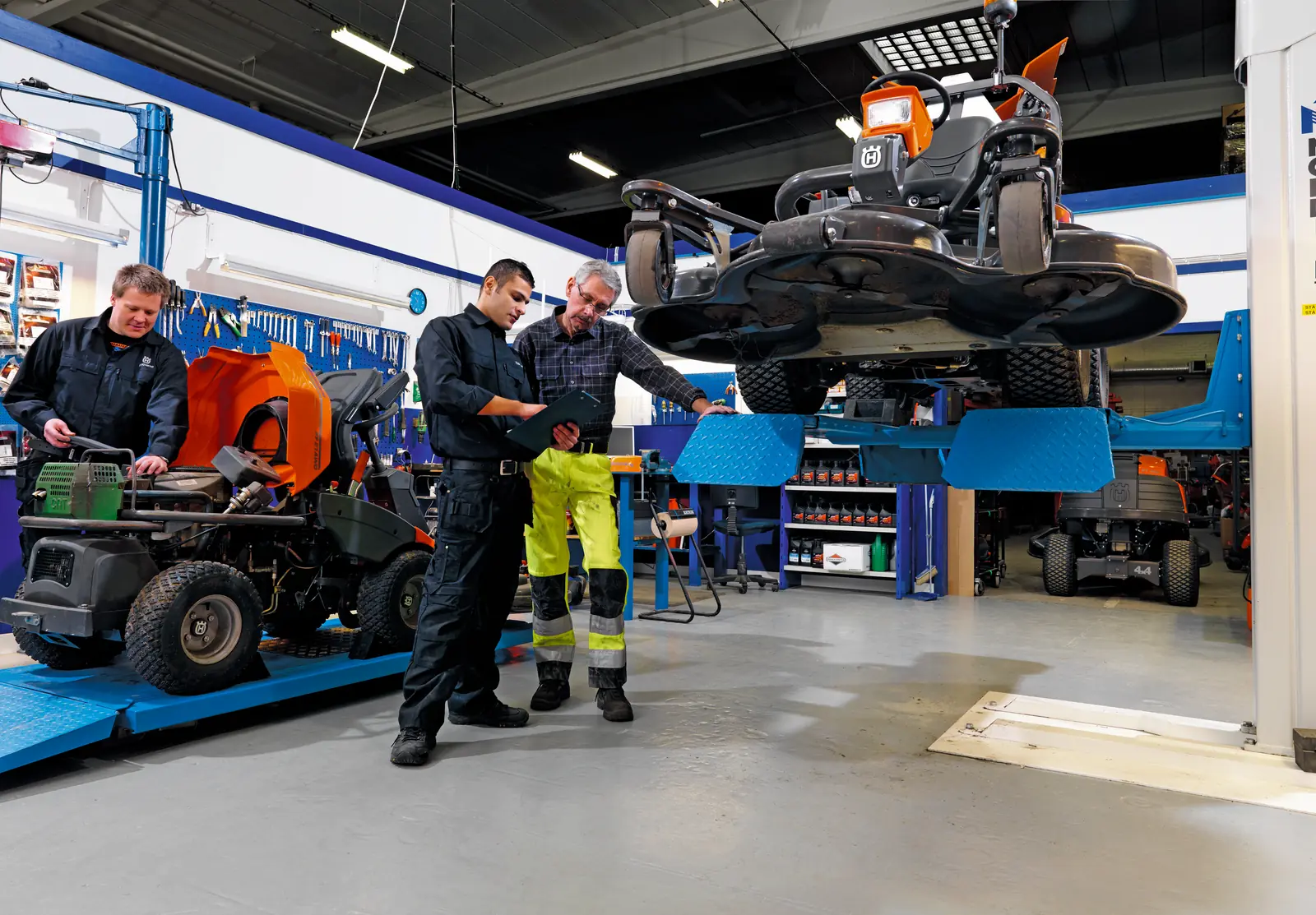 Monteurs aan het werk aan een zitmaaier in de werkplaats